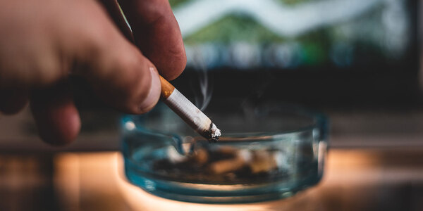 hand putting out cigarette in ashtray